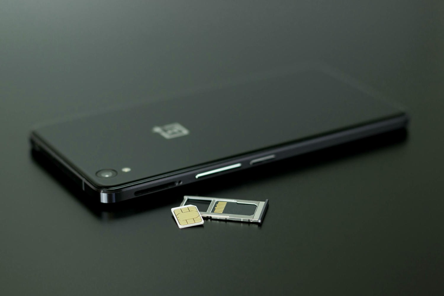 日本上網方式|日本網卡推薦 —— SIM卡・eSIM・wifi機 - 第4張圖 Close-up of a smartphone with a SIM card and memory card, showcasing modern technology.